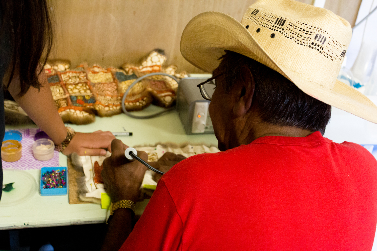 A man inscribes a possum skin cloak